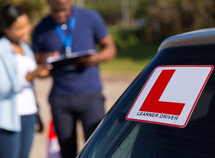 An instructor assisting a student in a driving course